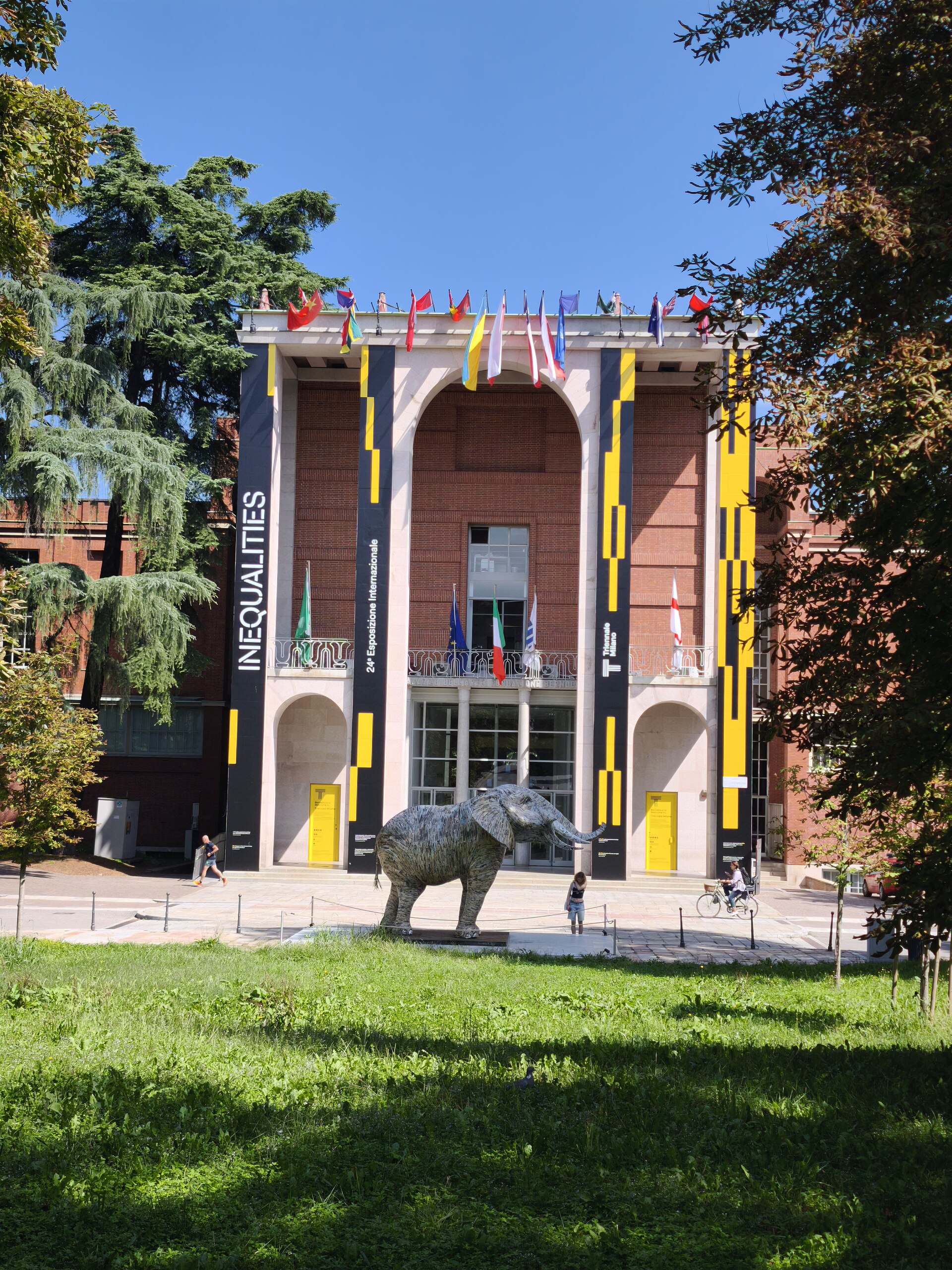 The facade of Palazzo dell’Arte, home of Triennale Milano, framed by the park’s trees