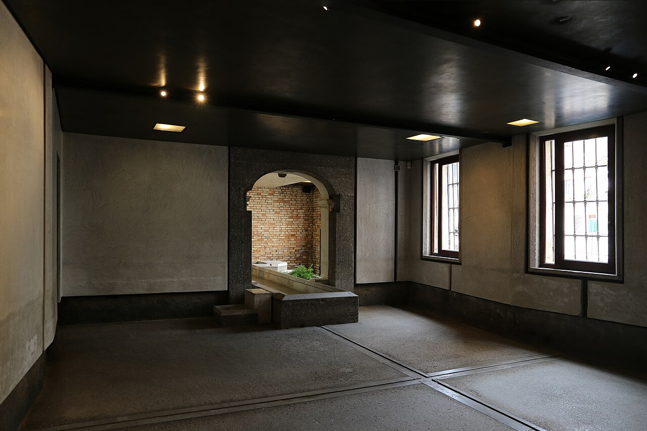 Ground-floor room at Querini Stampalia in Venice, with patterned floor joints, windows and an opening towards the garden in Carlo Scarpa’s intervention