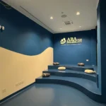 Sala del Centro ABA for Disability di Salerno con pareti blu, onda color sabbia e gradoni con sedute a forma di sasso