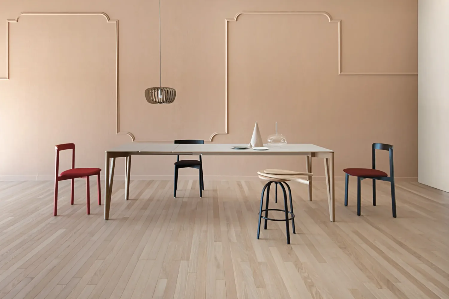 Zona pranzo con pareti rosa cipria e boiserie e parquet in rovere chiaro