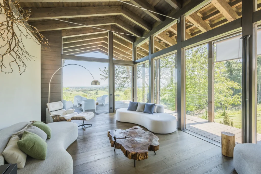 Rubner Haus living room with exposed timber structure and large windows facing the garden