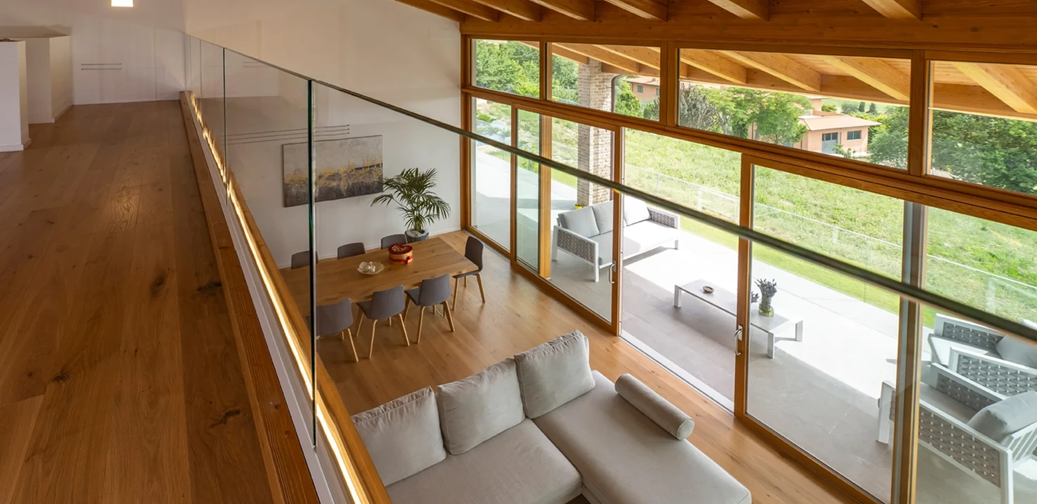 Double-height living space in a Subissati timber home with exposed beams and large windows