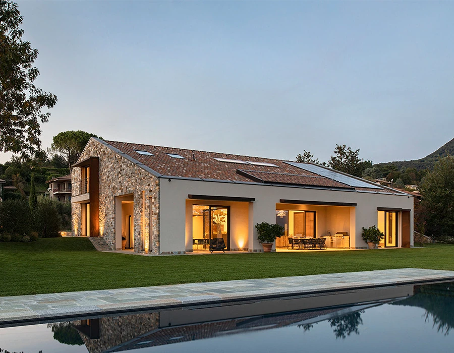 Wolf Haus home at dusk with an illuminated porch and garden