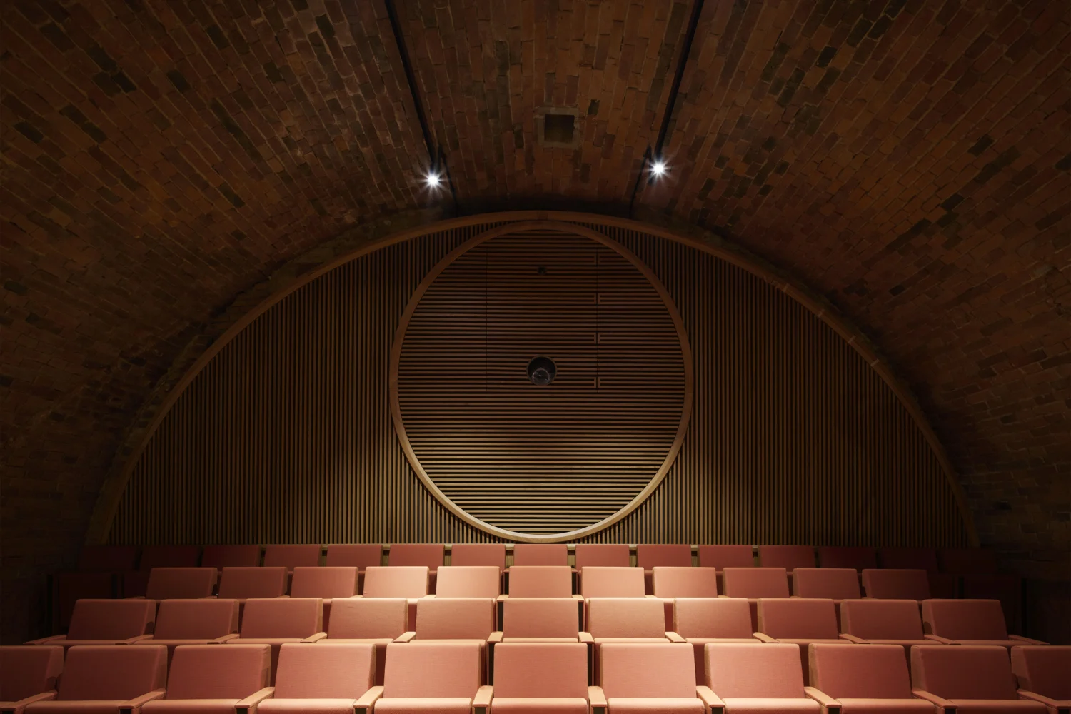 La sala del Teatro di Vitigliano a Greve in Chianti con le poltrone rosse, MDU architetti
