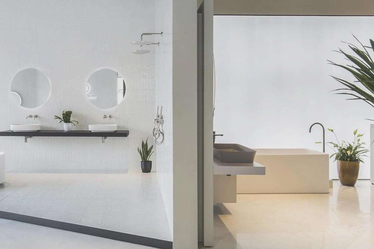 White bathroom with wall-hung basin shelf, round mirrors and open shower area
