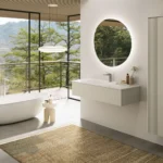 Bright contemporary bathroom with freestanding bath, wall-hung vanity and floor-to-ceiling windows