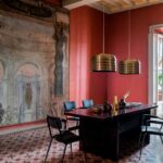 Ambiente rosso vino con sedute blu e lampade in ottone a Palazzo Bacchetta, Studio 2046, Treviglio