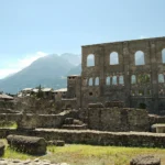 La facciata del teatro romano di Aosta con gli ordini sovrapposti di arcate e le montagne sullo sfondo