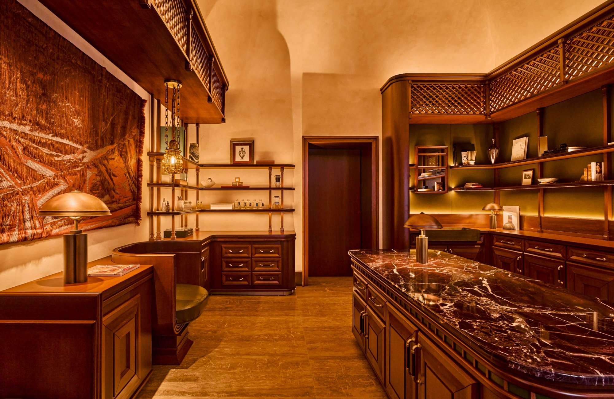 Area di accoglienza della spa dell’Orient Express La Minerva a Roma con boiserie in legno, grate a traliccio e bancone in marmo rosso